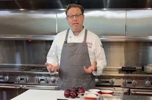 Fresh chef demonstrating culinary skills in commercial kitchen, highlighting professional cooking expertise.